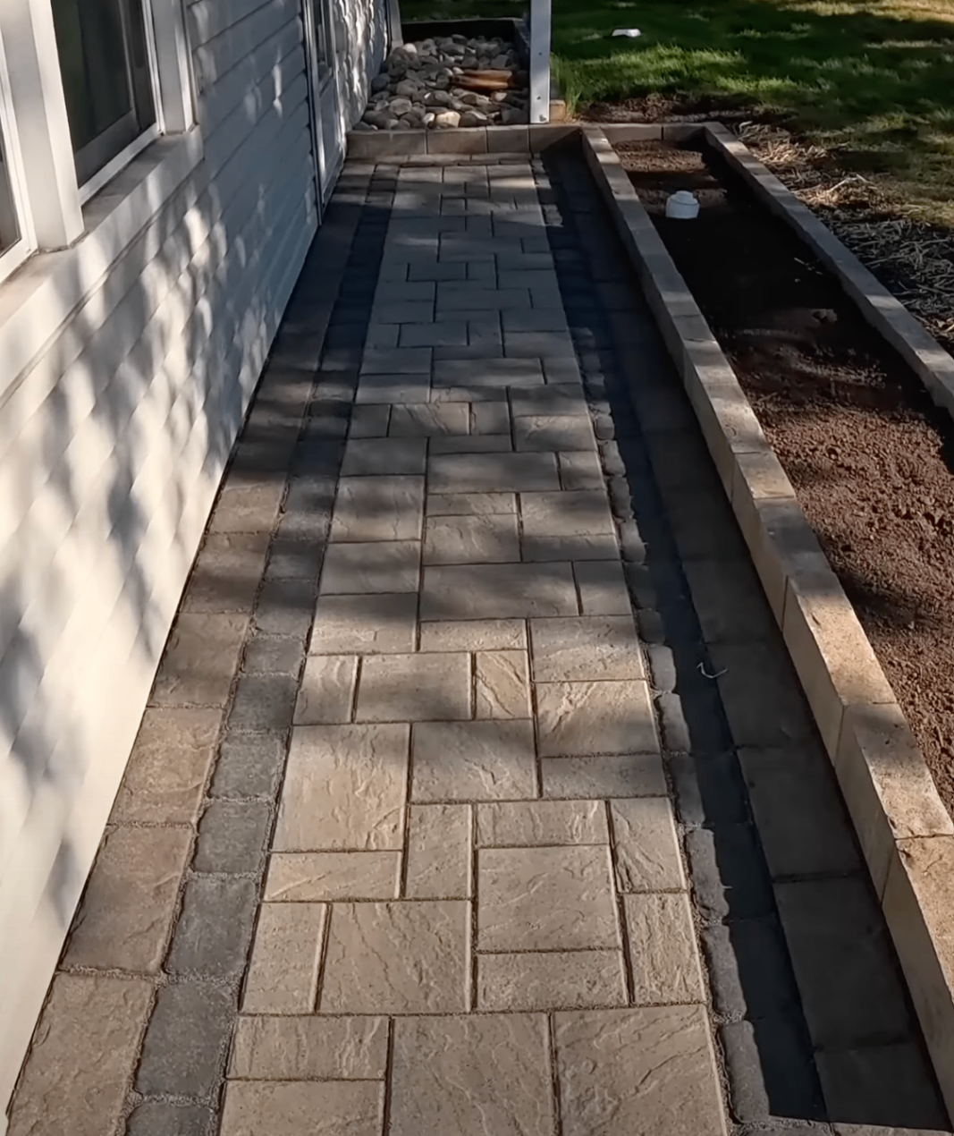 crew buggying concrete through a backyard gate for a fenced patio pour